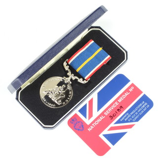 A cased National Service medal 