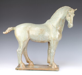 A stylish pottery figure of a standing horse raised on a rectangular platform, signed C S, 48cm