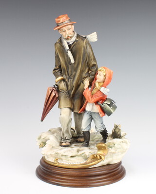 A Capodimonte group of an elderly man with child in a snowy landscape 28cm 