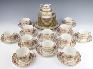 A Limoges tea set with rose and gilt decoration comprising cream jug, sugar bowl, 12 cups, 12 saucers, 12 side plates and 2 sandwich plates