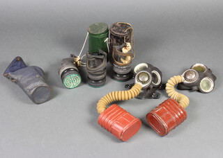 Two Second World War service respirators, 2 civilian respirators contained in a metal canisters and 1 other in a leather cloth case 