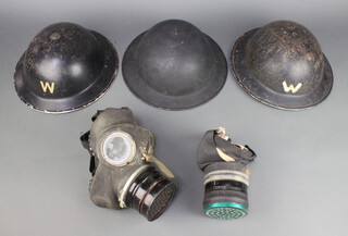 A Second World War Air Raid Wardens helmet marked 1939 G34RMB complete with liner, 1 other helmet marked O34 1939 complete with liner (chin strap f), 1 other black painted steel helmet marked 1946 U30, a Civil Defence respirator and a civilian ditto 