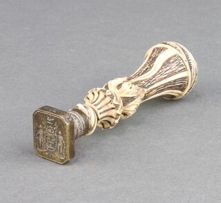 A Victorian metal seal with armorial decoration and carved bone stem 9cm x 1cm x 2cm 