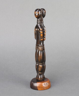 A curious lignum vitae carved figure of 2 back to back ladies, raised on a turned base 22cm x 5cm 