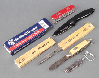 A Smith and Wesson folding knife with 7.5cm blade boxed, a Swiss Army pen knife, a multi bladed knife, a Fico pocket knife and a fishing knife contained with a ruler 