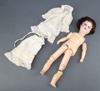 A 19th Century porcelain headed doll with open and shutting eyes, head incised Armand Marseille 390A50XM with articulated body (1 leg a/f) together with a dress and a skirt   