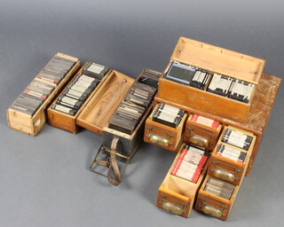 A pine table top filing chest containing approx. 126 black and white photographic slides together with 4 rectangular pine trays containing approx. 270 black and white slides 