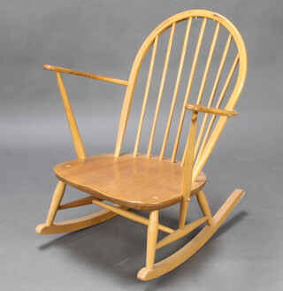 Ercol, a light elm stick and rail back rocking chair, the seat with Ercol sticker