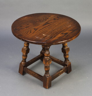 A circular oak occasional table raised on turned and block supports with box framed stretcher 40cm x 50cm (light scratches to the top)
