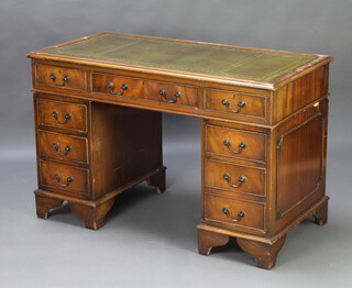 A Georgian style kneehole pedestal desk with inset green leather writing surface above 1 long and 8 short drawers, raised on bracket feet 78cm h x 122cm w x 60cm d