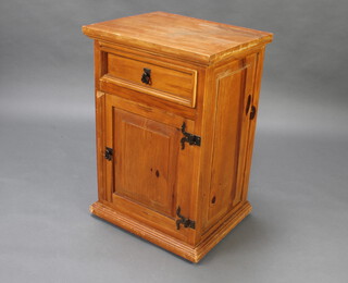 A pine bedside cabinet fitted a drawer enclosed by a panelled door 73cm h x 49cm w x 41cm d 