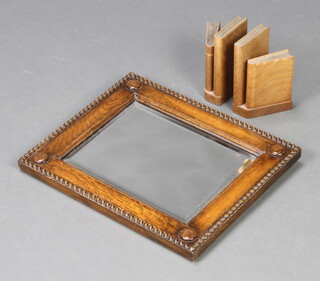 An Art Deco rectangular bevelled plate wall mirror contained in a carved oak frame 33cm h x 41cm w together with a pair of Art Deco wooden book ends in the form of books 16cm x 9cm x 9cm 