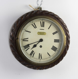 An Edwardian timepiece with painted dial and Roman numerals contained in a carved oak case with rope edge decoration, the dial marked Carter Bowles of Cheltenham complete with key 