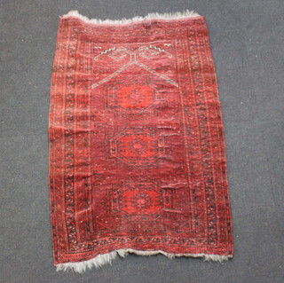 A red ground Afghan rug with 3 diamonds to the centre within a multi row border 150cm x 98cm 
