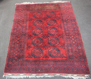 A red and black ground Afghan carpet with 10 octagons to the centre within a multi row border 300cm x 231cm 