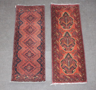 Two similar brown and black ground machine made rugs 149cm x 53cm 