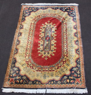 A red, gold and blue ground Persian style machine made rug with oval central medallion 259cm x 182cm 