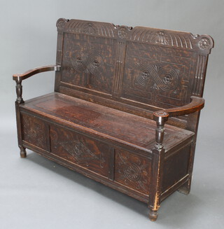 A Victorian carved oak settle with hinged lid 99cm h x 124cm w x 45cm d 