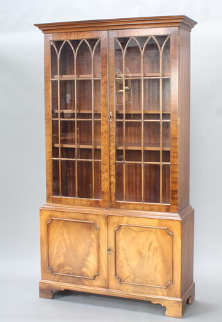A Georgian style mahogany display cabinet, the upper section with moulded cornice, fitted shelves enclosed by astragal glazed doors, base enclosed by panelled doors, raised on bracket feet 185cm h x 101cm w x 34cm d 
