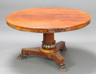 A William IV circular mahogany snap top breakfast table raised on a chamfered column and tripod base with paw feet 70cm h x 133cm diam. 