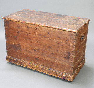 A 19th Century pine trunk with hinged lid and iron drop handles, raised on a platform base 64cm h x 94cm w x 47cm d 