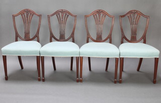 A set of 4 mahogany Hepplewhite style shield back dining chairs with over stuffed seats, raised on square tapered supports, spade feet 