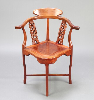 A Chinese carved and pierced hardwood corner chair raised on cabriole supports with X framed stretcher 