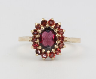 A 9ct yellow gold oval garnet cluster ring, size N, 2.6 grams