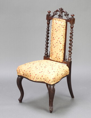 A Victorian mahogany nursing chair with spiral turned columns, of serpentine outline, having an upholstered seat and back and raised on cabriole supports 