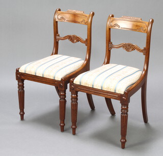 A pair of Georgian mahogany bar back dining chairs with shaped mid rails and drop in seats, raised on turned and reeded supports 