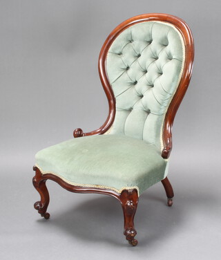 A Victorian mahogany spoon back nursing chair upholstered in blue buttoned material, raised on cabriole supports 