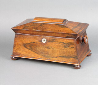 A Victorian rosewood twin compartment tea caddy of sarcophagus form, interior with associated mixing/sugar bowl with tore handles to the side, raised on bun feet 20cm h x 36cm w x 20cm d 