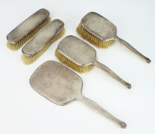 A silver engine turned 5 piece dressing table set comprising 1 hand mirrors, 2 clothes brushes, 2 hair brushes, London 1942