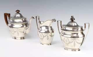 A good silver Tiffany & Co tea set with engraved floral swags, festoons and ribbons with armorial, having fruitwood mounts, impressed mark Tiffany & Co 550 Broadway no.371, 1501 grams gross 