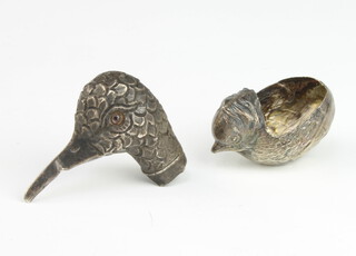 A George V silver pin cushion base in the form of a chick, lacking interior, Chester 1911 and a repousse silver mount in the form of a ducks head, 16 grams