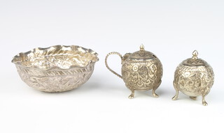 A repousse Indian silver bowl decorated with scrolling flowers 10cm, a pair of ditto condiments 185 grams