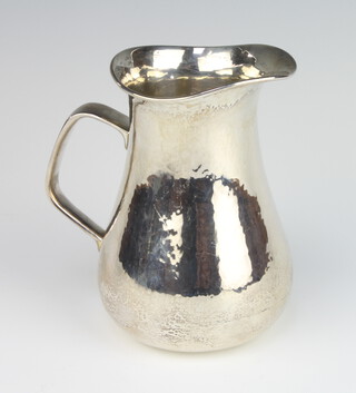 A silver hammered pattern jug with stylish handle, London 1985, 15cm, 465 grams