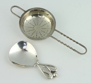A stylish sterling silver caddy spoon together with a tea strainer 80 grams 