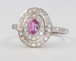 A platinum oval pink sapphire and diamond cluster ring, the centre stone approx. 0.5ct, diamonds 0.5ct, size Q, 4.4 grams 