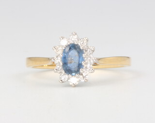 An 18ct yellow gold oval sapphire and diamond cluster ring, sapphire approx. 0.5ct, diamonds 0.25ct, size N 