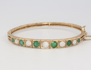 A 9ct yellow gold bangle set opals and emeralds 13.4 grams