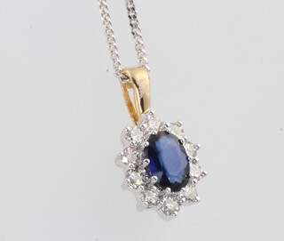 An 18ct yellow gold oval sapphire and diamond cluster pendant 18mm on a silver chain, centre stone approx. 1ct, diamonds 0.5ct