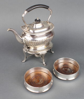 A silver plated tea kettle and stand with burner and a pair of coasters