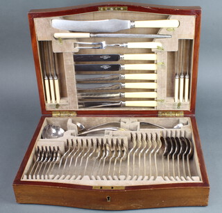 A mahogany serpentine fronted inlaid canteen containing a set of plated cutlery for 6 