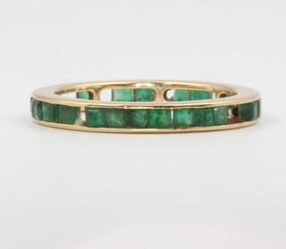 An 18ct yellow gold emerald eternity ring, 2.8 grams, size P 