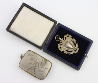 A silver sports fob and a plated vesta 