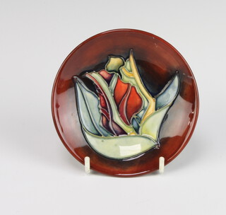 A modern Moorcroft circular dish the red ground decorated with a flower 12cm 
