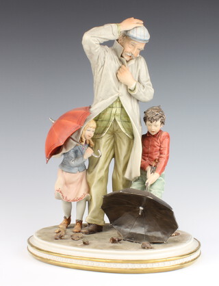 A Capodimonte figure group of an elderly gentleman with 2 children holding umbrellas 39cm 