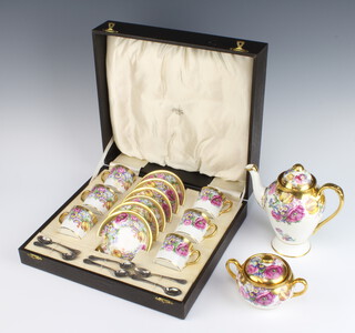 A porcelain polychrome and gilt floral coffee set comprising 6 coffee cans and saucers with plated spoons cased, together with a coffee pot and lidded sugar bowl