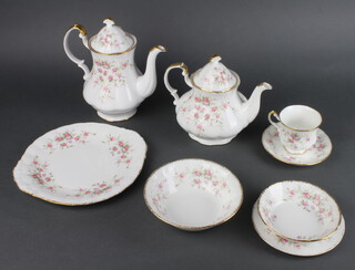 A Royal Albert Victoriana rose pattern tea and dinner service comprising 10 tea cups, 10 saucers, tea pot, coffee pot, milk jug, cream jug, 2 sugar bowls, 11 small plates, 8 dessert bowls, 6 soup bowls, sandwich plate, serving plate, shell dish and 2 oval dishes